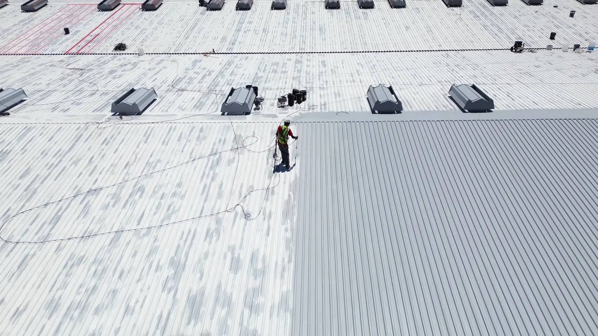 Worker applying industrial roof coatings on commercial roof in Gauteng