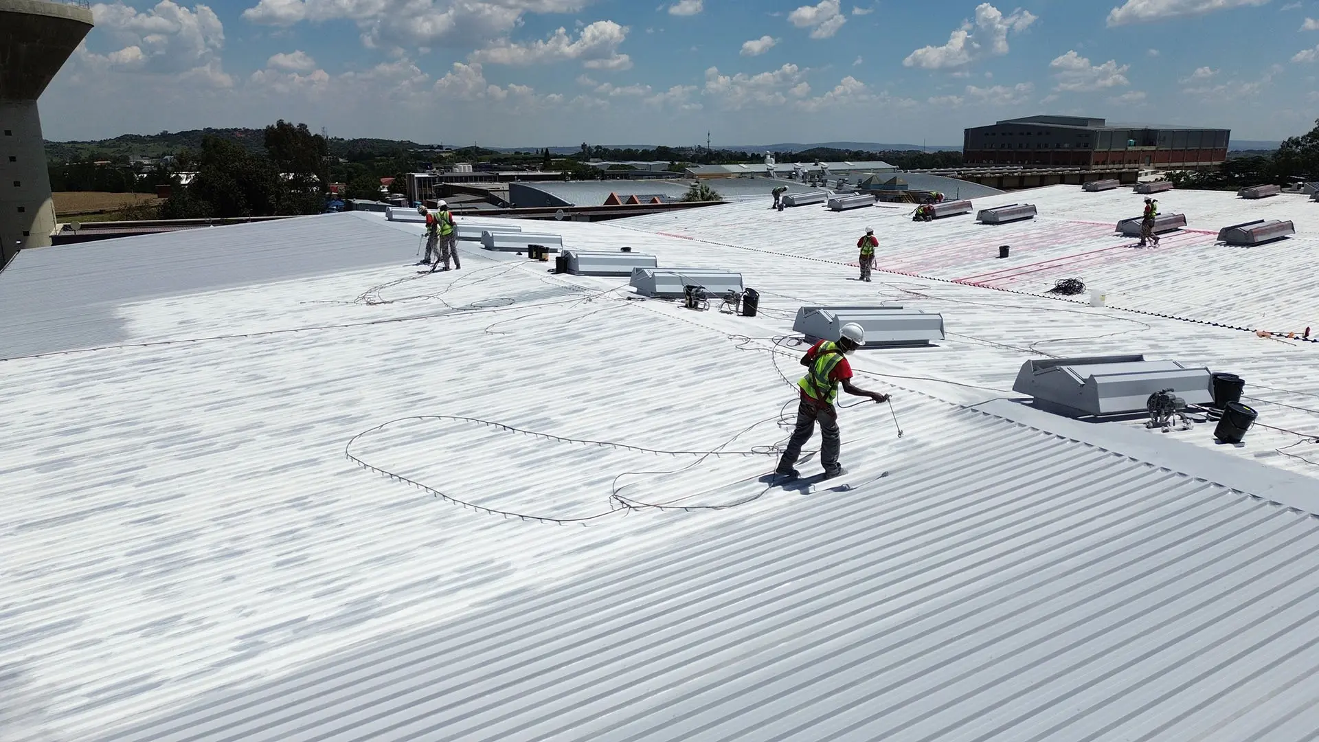 Sicon Group workers applying a commercial roof coating service on a Gauteng property